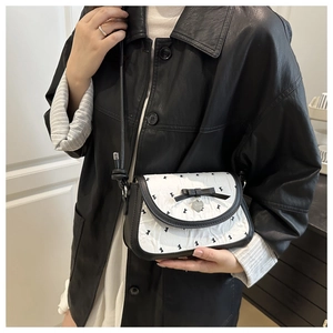 Détail d'un sac bandoulière contrasté avec texture plissée et décoration de nœud noir
