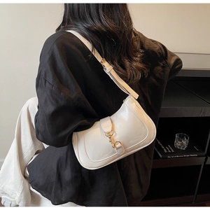 Sac hobo chic blanc crème avec boucle dorée porté à l'épaule pour le quotidien