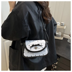 Sac bandoulière chic avec nœud papillon et motif lapin porté par un mannequin de côté