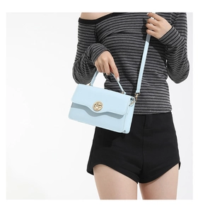 Gros plan du petit sac à main bleu clair avec fermoir rotatif métallique doré chic