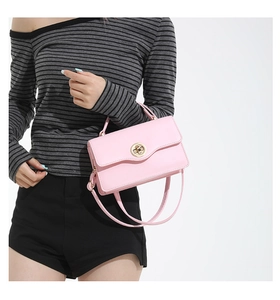 Détail du sac à bandoulière rose avec rabat ondulé et fermoir rotatif doré