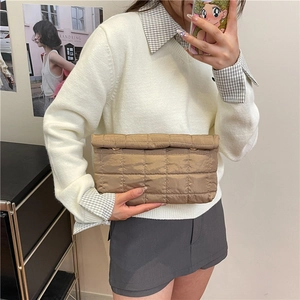Mirror selfie showing the khaki quilted square clutch bag with embroidery and plaid patterns