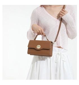 Détail du sac en similicuir marron avec fermoir rotatif rond en métal doré