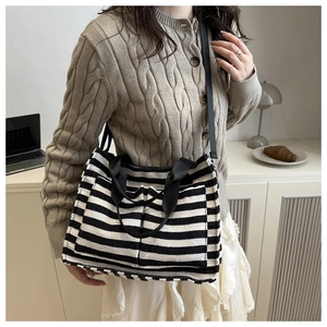 Detail of striped canvas tote bag with front pockets and dual handles for daily use