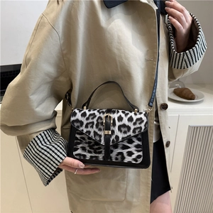 Chic black and white leopard print crossbody bag with gold buckle and top handle