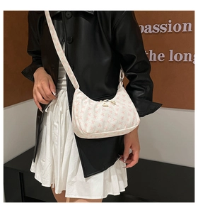 Detailed view of women's corduroy hobo bag with pink bow print on a shoulder model