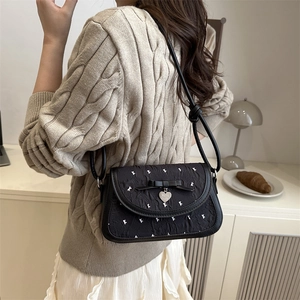 Sac floral contrasté avec nœud en soie noire et pendentif cœur argenté sur la bandoulière