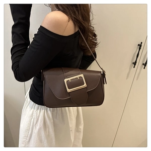 Detailed side view of deep brown faux leather shoulder bag with a large gold metal buckle