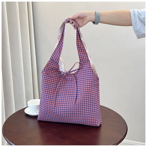 Detail der blau-orangen Gingham-Einkaufstasche mit Blumenfutter und gewebter Schleife