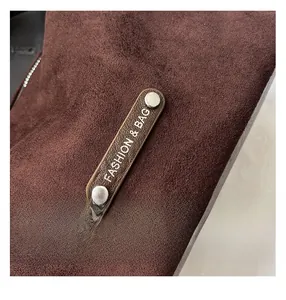 Close-up of suede texture and silver studs with Fashion & Bag logo on dark brown crossbody