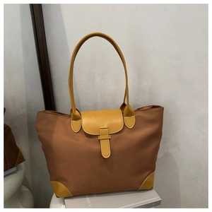 Detail of contrast color tote bag with yellow leather trim and brown nylon fabric