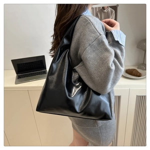 Détail d'un sac hobo minimaliste en cuir noir brillant pour le bureau moderne
