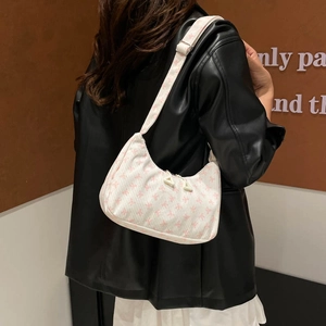 Sac sous les bras en velours côtelé blanc avec imprimés roses sur un modèle femme