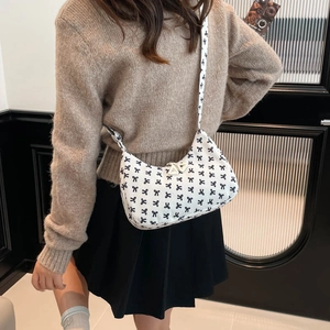 White corduroy crescent bag with black bow print and stylish wide shoulder strap