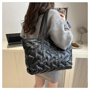 Vue arrière d'un mannequin avec un grand sac cabas matelassé noir dans un décor de bureau calme
