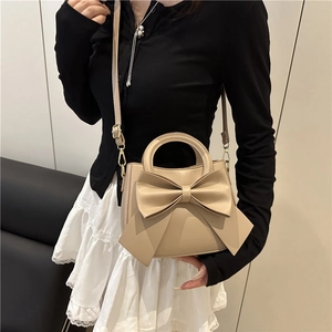 Beige faux leather handbag with a large bow detail and gold hardware for women