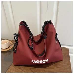 Detail der weinroten Nylontasche mit dicken Seilgriffen und modischem Fashion Aufdruck