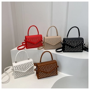 Detailed display of five small crossbody bags in various colors with metallic stud accents