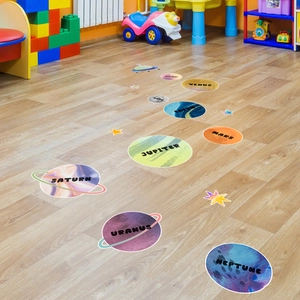 Solar system planet floor stickers for kids room featuring planets and moon on wood floor