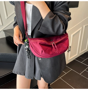 Detail van de bordeauxrode halve maantas met nylon textuur en verstelbare riem