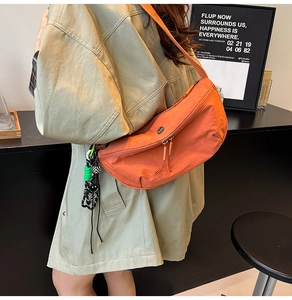 Detail van de feloranje halve maan tas met nylon textuur en trendy sleutelhanger