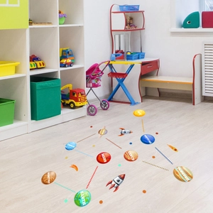 Solar system floor decals for kids rooms featuring planets and rockets on light wood