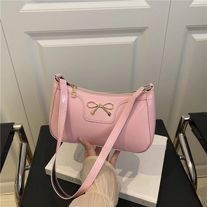 Bolso de hombro de charol rosa con lazo dorado y acabado de espejo brillante