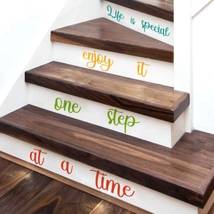 Close-up of colorful inspirational quote stickers on wooden stairs showing Life is special