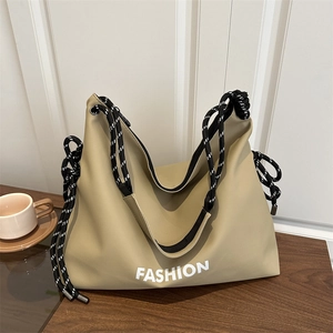 Khaki Nylon-Tragetasche mit gestreiften Seilgriffen und FASHION-Schriftzug auf Holz