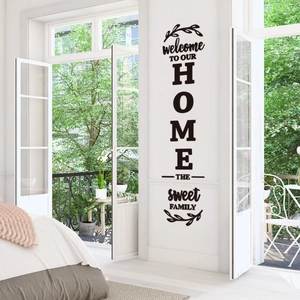 Detail of Welcome To Our Home wall sticker with leaves on a minimalist white interior wall