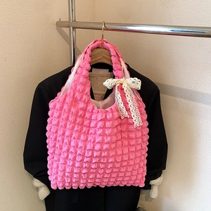 Pink bubble pleated tote bag with white lace bow hanging on a wooden hanger