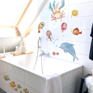 Close-up of watercolor sea animal wall stickers applied to white bathroom tiles