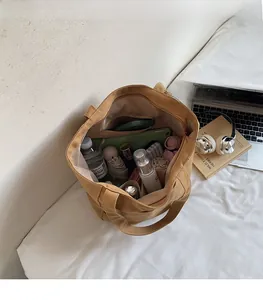 Top view of spacious canvas tote interior holding umbrella, water bottle, and daily items