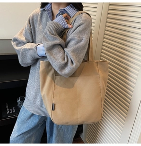 Detail of khaki canvas tote bag showing the side fashion tag and premium stitching