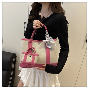 Detailed close-up of canvas garden tote bag with pink leather trim and silk bow accessory