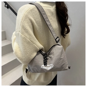 Détail du sac croissant en nylon gris avec lettrage FANYISSA blanc et cordon de serrage