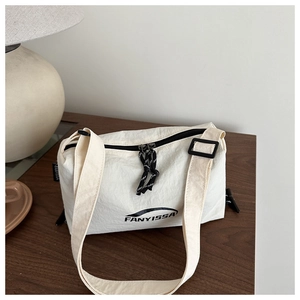 Détail du sac bandoulière en nylon blanc cassé avec fermetures noires et logo FANYISSA