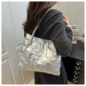 Detail of silver tote bag with embossed bear pattern and braided shoulder strap