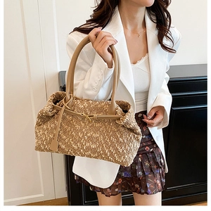 Detailed view of brown fleece tote bag with leather straps and golden hardware buckles