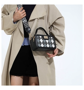 Close-up of checkered crossbody bag with wide patterned strap on model