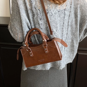 Retro caramel rectangular crossbody bag with silver rivets and top handle on a model