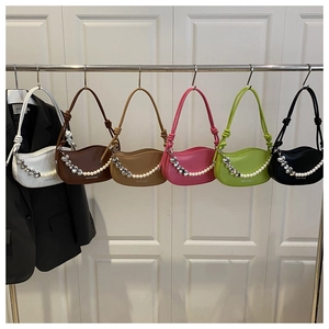 Detail of candy-colored crescent underarm bags with heart pearl chains and knotted straps