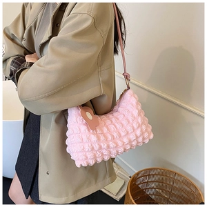 Détail du sac nuage rose avec texture bulle et breloque fleurie sur la bandoulière