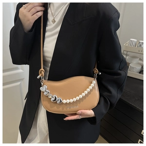Detail of khaki leather saddle bag with heart pearl charm and wave flap detail
