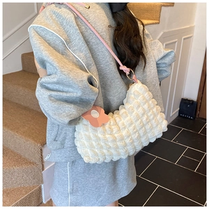 Détail du sac nuage blanc texturé avec bandoulière rose et pendentif fleur assorti