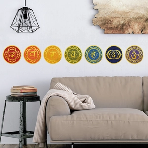Modern wall decor set of seven colorful chakra symbols above a minimalist sofa