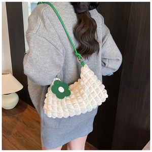Détail du sac nuage blanc à texture bulles avec bandoulière verte et pendentif fleur