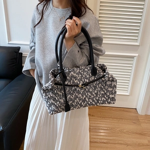 Fashionable black and white tweed handbag with leather straps and gold metal buckle