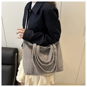 Detailed texture of gray corduroy tote bag showing vertical ribbed fabric and shoulder strap