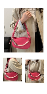 Detail of pink underarm bag with silver heart charm and white faux pearl chain decoration